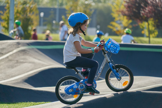 The bike lane for children. Children have fun on the race track. A child in a blue helmet riding a bicycle for safety