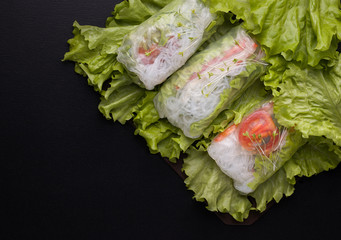 spring rolls with vegetables in rice paper on a black background.copy spaces
