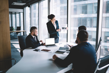 Pensive coworkers inspecting graphs in office