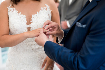 der Bräutigam steckt der Braut den Ehering auf