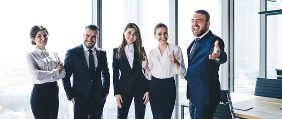 Positive modern employees standing in office