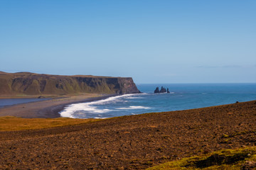 Famous Reynisdrangar rock formations at black Reynisfjara Beach. Coast of the Atlantic ocean near Vik, southern Iceland. September 2019