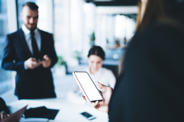 Manager sharing information with colleague through smartphone in hand