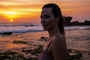 Woman against Pura Tanah Lot temple , Bali