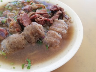 Yellow noodle soup with vegetables, beef and meatballs
