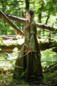 Elf woman in a green dress in the forest