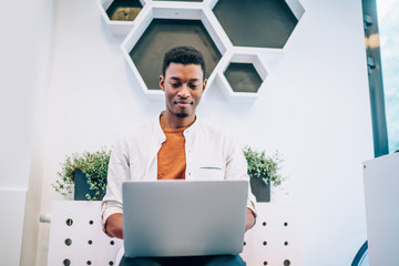 Skilled male programmer with dark skin developing web platform for IT professionals using 4g...