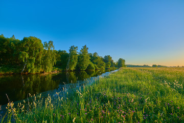 Peaceful rural summer european landscape with green trees and water