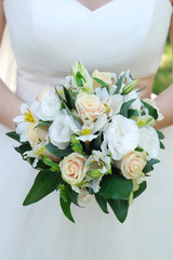 Bride holding wedding bouquet. Beautiful flowers in the hands of a woman.
