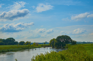 Peaceful rural summer european landscape with green trees and water