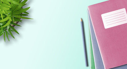 directly above shot of notebook or exercise book with blank adhesive label and pencil on desk with...