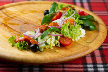 Vegetarian salad of pickled vegetables and cheese. Greek satate with pepper, cucumber, cheese, olives and lettuce seasoned with olive oil