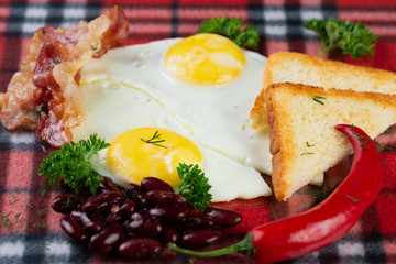  fried eggs with icing, bacon, beans, bread croutons with hot chilli peppers