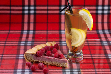  raspberry and cream pie with hot drink with lemon and cinnamon stick