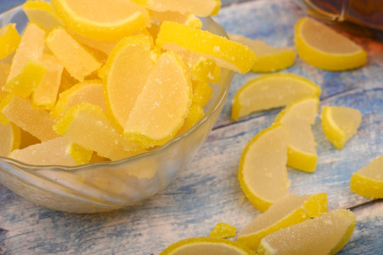 Marmalade lemon slices on wooden background. Sweet dessert. Close up.