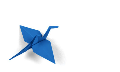 Blue origami crane isolated on white background.