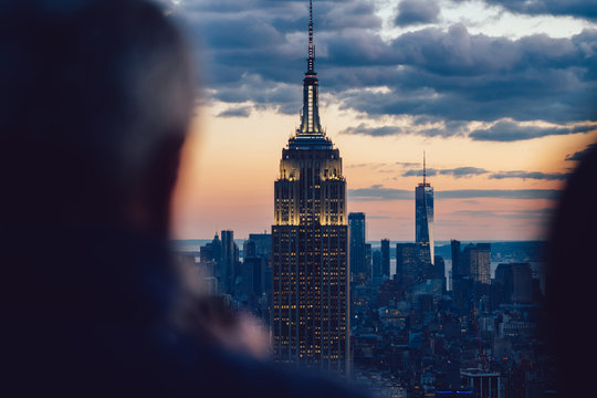 Aerial view of glowing skyscraper with bright buildings around located in Manhattan district of New York city. Famous landmark Empire State Building, beautiful skyline background, perfect wallpaper