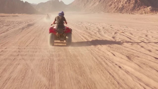 Quad bike ride through the desert near Sharm el Sheikh, Egypt.Adventures of desert off-road on ATV.Sand and Sand Borkhan. Rock and sunset. Quad Cycle Travel. Excursion with people.
