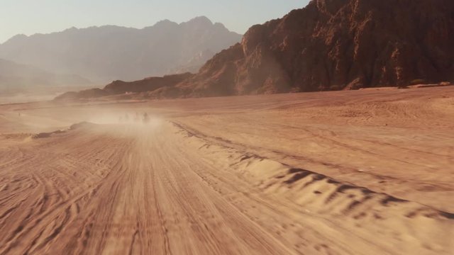 Quad bike ride through the desert near Sharm el Sheikh, Egypt.Adventures of desert off-road on ATV.Sand and Sand Borkhan. Rock and sunset. Quad Cycle Travel. Excursion with people.