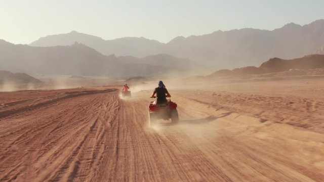 Quad bike ride through the desert near Sharm el Sheikh, Egypt.Adventures of desert off-road on ATV.Sand and Sand Borkhan. Rock and sunset. Quad Cycle Travel. Excursion with people.