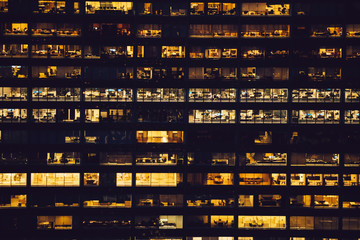 Aerial view of various high Manhattan skyscrapers buildings with lighted windows located in New York city at evening time. Night life of metropolis, offices and real estate. Downtown structures
