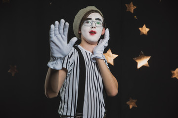 A MIME in a striped shirt in a circus tent shows a sketch