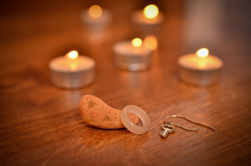 Lighted candles and paraphernalia for the magic rite. Ring made of natural stone. 