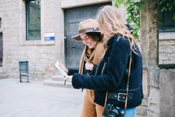 Female travelers checking direction on city map