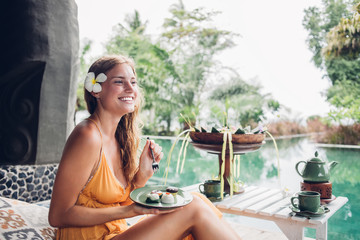 Happy female with delicious pastries on poolside