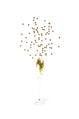 Golden color confetti pouring from champagne glass isolated on white background. Festive party concept.