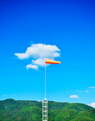 Windsock flag on blue sky background. Wind speed meter