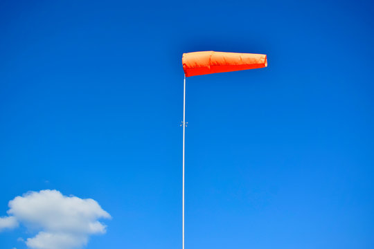 Windsock flag on blue sky background. Wind speed meter