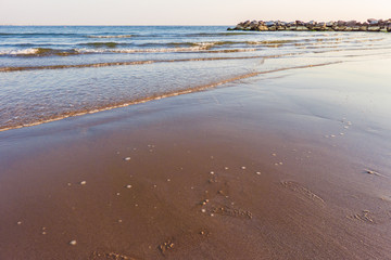 Waves on Sandy Beach Background at Sunrise or Sunset