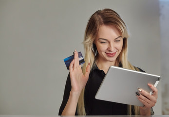 Fototapeta premium woman with credit card shopping online on digital tablet while lying at home