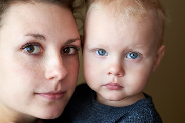 Portrait of a mother with brown eyes and her little son with blue eyes.