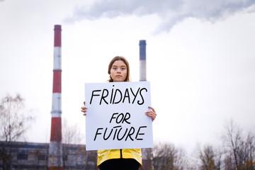 Teenager girl holding placard during global strike for climate change     
