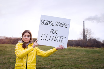 Teenager girl holding placard during global strike for climate change     