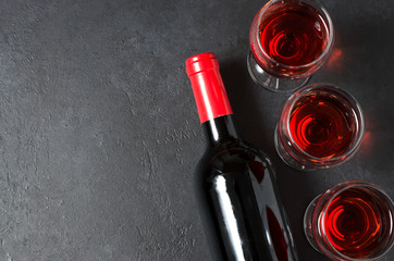 Red wine in glasses. Bottle of wine. Dark background. Copy space