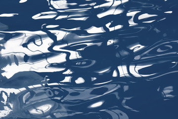 Blue pool water with sun reflections. Abstract blurred pattern.
