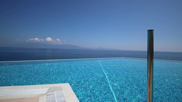 Infinity pool on Kos island in Greece. Walking along the pool overlooking the sea. Shot in motion.