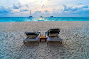 Lounge chairs on a beautiful tropical beach at Maldives