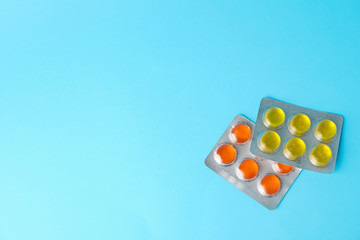 Medical candies in blister packs on blue background, space for text