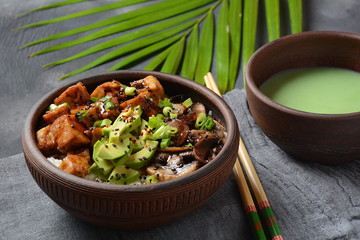 Sweet, spicy , crispy and fried Tofu in a bowl with terriayaki sauce, avocado,fried mushrooms, sesame seeds and rice. Served with green Matcha Tea. Healthy vegan food, gluten-free