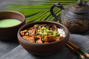 Sweet, spicy , crispy and fried Tofu in a bowl with terriayaki sauce, avocado,fried mushrooms, sesame seeds and rice. Served with green Matcha Tea. Healthy vegan food, gluten-free