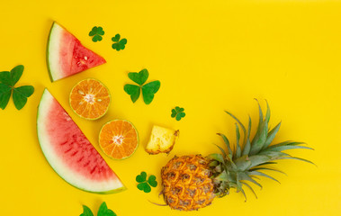 exotic tropical fruits, pineapple, orange, watermelon isolated on a yellow background