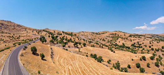 Aerial view of Kahta Sincik Road, close to Katha river near the village of Taslica, District of Kahta, Adiyaman Province, Turkey. Winding roads surrounded by nature with cars and vehicles