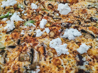 Delicious pizza closeup of a jumbo sized fatty pizza served and baked in a restaurant with different vegetables, cheese, cream and dough crust