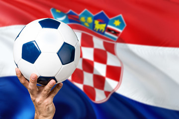 Naklejka premium Croatia soccer concept. National team player hand holding soccer ball with country flag background. Copy space for text.