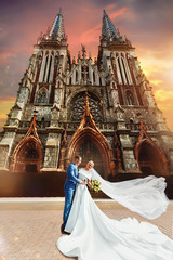 Beautiful newlywed couple walk near old christian church