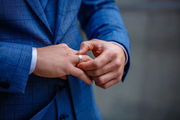 Groom in a suit holding ring